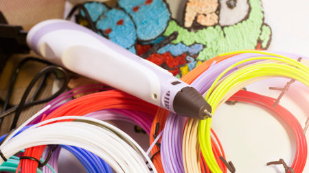 Purple 3d pen and rolls of colored plastic, creative tool