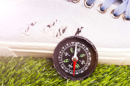 Compass and sneakers on green grass, closeup. Sport equipmentの写真素材
