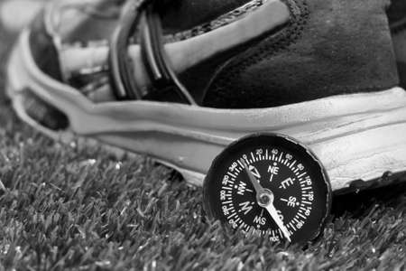 Compass and shoes on the grass. Black and white photo.の写真素材