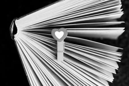 Open book with a heart-shaped bookmark. Black and white photo.の写真素材