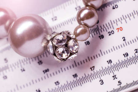 Jewelry, accessories and measurement tools concept - close up of pearl earrings and rulerの写真素材