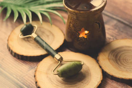 Jade face roller and jade gua sha tool on wooden backgroundの写真素材