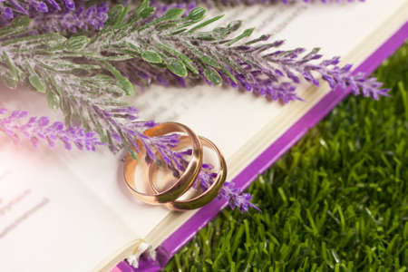 Wedding rings on a sawn tree and a bouquet of lavenderの写真素材