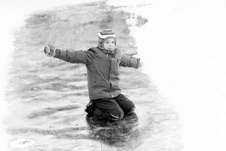 Funny boy rides down an ice slide, winter funの写真素材