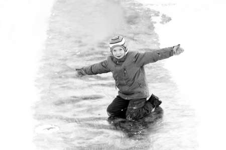 Funny boy rides down an ice slide, winter funの写真素材