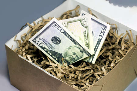 Money in a cardboard box on a gray background. Close-up.の写真素材