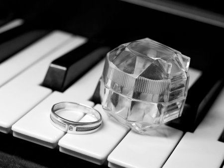 Wedding rings on the piano keys. Black and white photo.