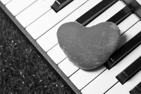Heart on piano keyboard, black and white tone, soft focus.の写真素材