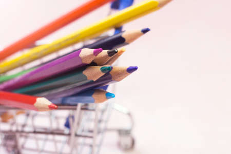 Shopping cart with colorful pencils on white background, closeupの写真素材