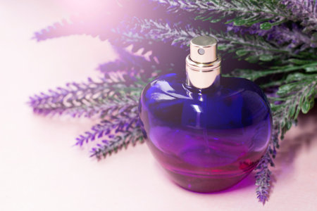 Perfume bottle and lavender branch on a light background.