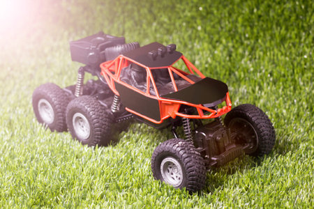 A toy model of a quad bike stands on a green lawn.