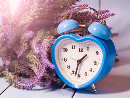Blue heart-shaped alarm clock and lavender