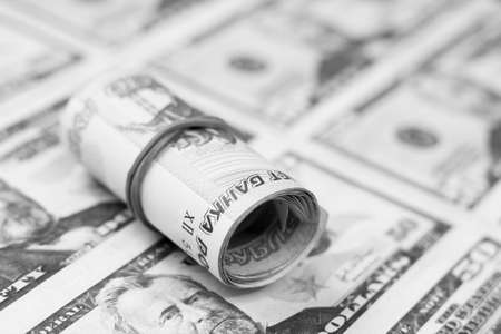 A roll of one hundred dollar bills. Black and white photo.の写真素材