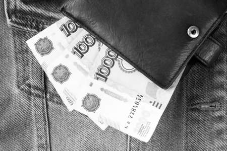 Money in a black wallet on jeans. Black and white photo.の写真素材