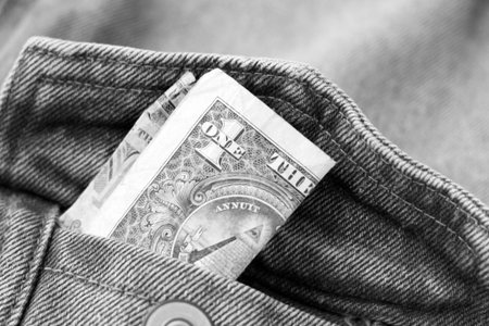 Close-up of one hundred dollar bill in jeans pocket. Black and white