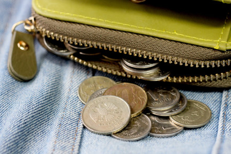 Green women's wallet with Russian coins on jeans