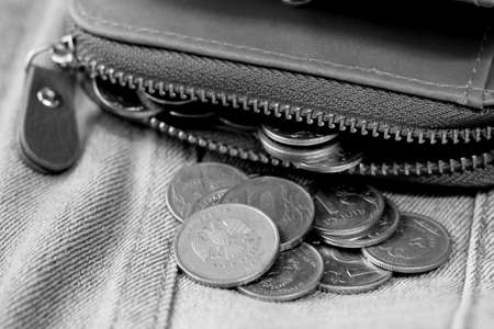 Coins in a black leather purse. Black and white photo.の写真素材