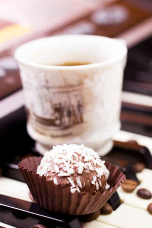 Chocolate cake with coconut and a cup of coffee on the pianoの写真素材