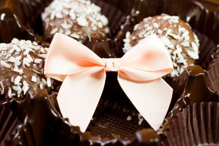 Chocolate cakes with coconut and pink bow, giftの写真素材