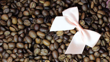 Pink satin bow on coffee beansの写真素材