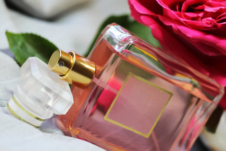 Bottle of perfume and roses on white fabric background, closeupの写真素材