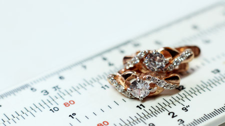 Gold earrings on a measuring device in a jewelry workshopの写真素材