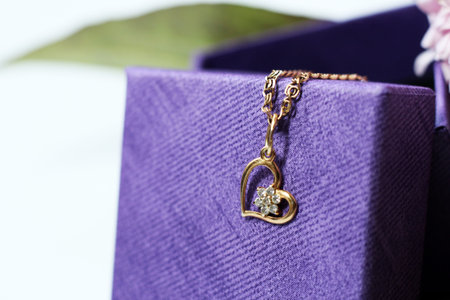 Close up of a gold pendant on a purple gift box.
