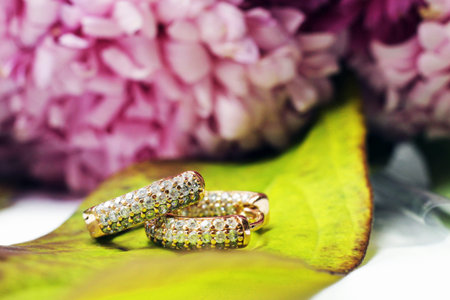 wedding rings on a green leaf with a bouquet of flowers