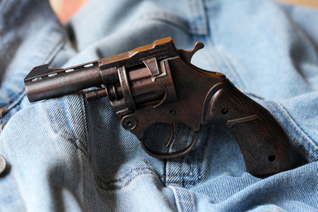 Revolver gun in the pocket of blue jeans, close-upの写真素材