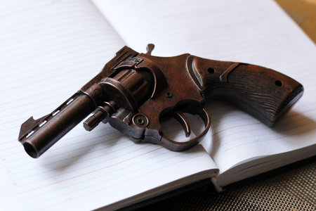 Old gun on a notebook, close-up, shallow depth of fieldの写真素材