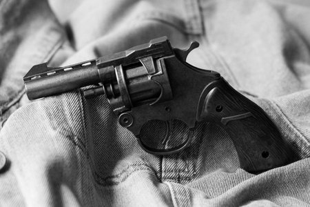 black and white photo of a revolver in jeans pocket close-up