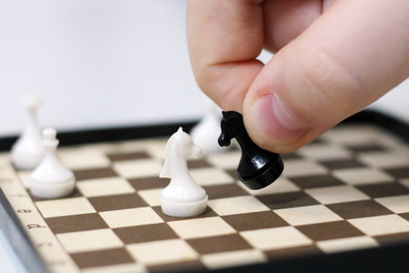 Close up image of human hand playing chess game with white and black kingの写真素材