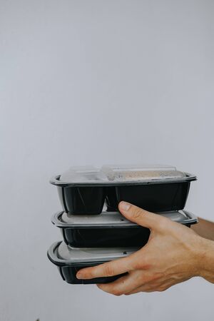 Food delivery. Man holds disposable food containersの写真素材