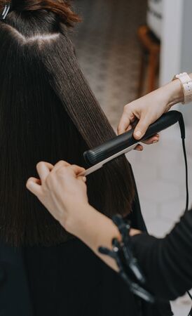 Womens haircut at home. Hairdresser cuts a girl at home.の写真素材