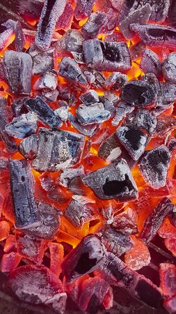 Hot red coals texture. Burning charcoals background. Close-up of a hot charcoals lying in a barbeque grill.の写真素材