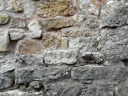 Old wall made of rocks. Medieval rocky surface. Texture of an old rocks and cement.の写真素材