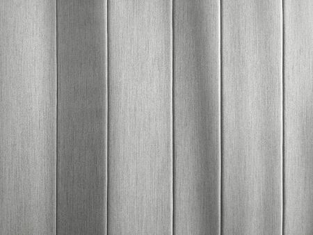 Linen fabric background with sun rays on it. Vertical stripes of gray fabric. Texture of cotton textile in interior.の写真素材