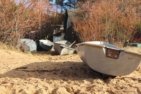 Fishing boats that are pulled ashore. Small boats in front of fisherman's cottage. Beach life that is captured during outdoor walk.の写真素材