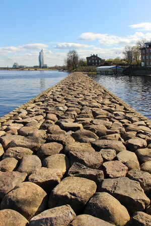 Rocky pier that separates harbor and quiet center district at the background.の写真素材