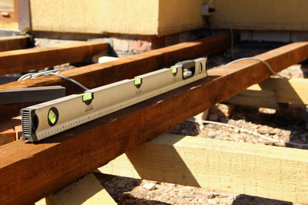 Level check of a wooden beam. Building level in use.