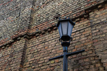 Old-fashioned street lantern in front of the old brick wall.の写真素材