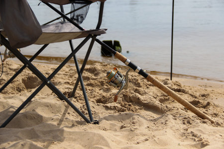 Folding chair and fishing rod stand at the beach. Fishing singly.