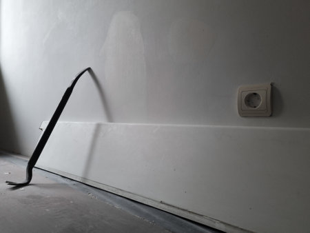 Close up of a used crowbar. Use of scrap for repair work in the house. Floor covering for protection during the house repair works. Iron scrap leaning against the wall.の写真素材