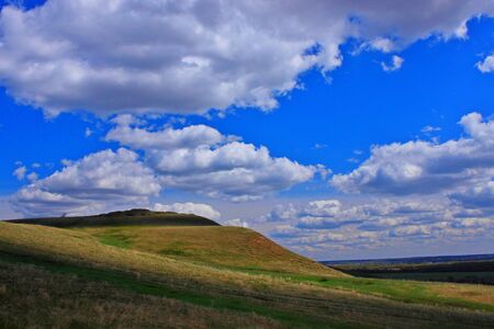 Photo of a cloudy sky over a hilly areaの写真素材