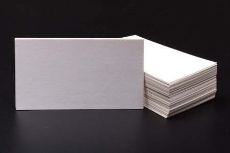 stacks of blank white business cards on a black surface. space for text