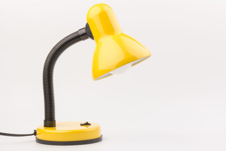 Yellow desk lamp isolated on white background. The concept of day and nightの写真素材