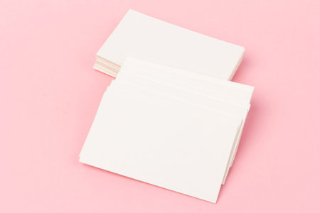 stacks of white blank business cards on pink background in close-up