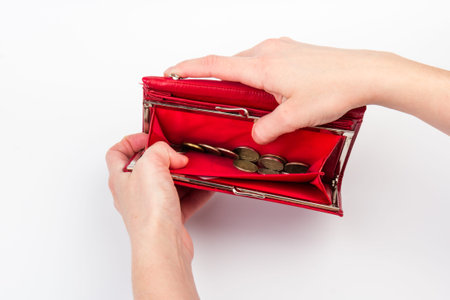 Woman opens her wallet to take out the last coin, isolated on white