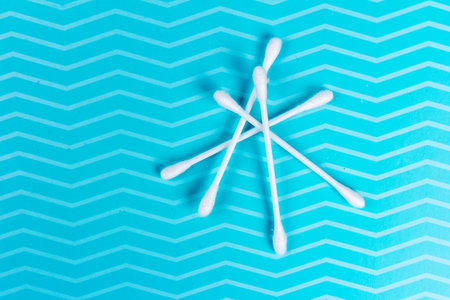 Cotton ear sticks on blue background. Makeup removal and skin care concept. Closeup, top viewの写真素材