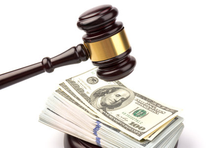 Wooden gavel with bancnotes on white background. Jude gavel on brown wooden table. Law, justice and auction.の写真素材